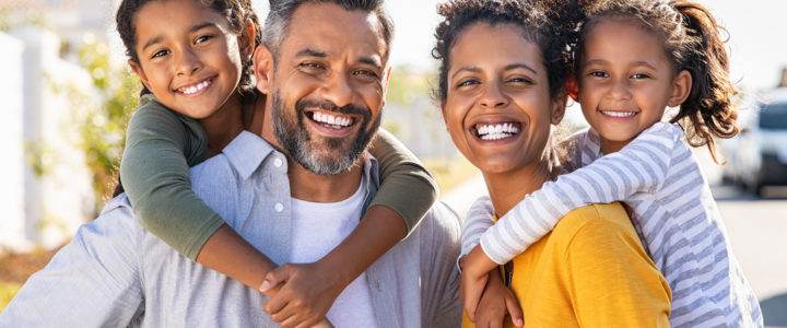 Multiethnic parents giving children piggyback ride