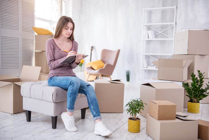 Charming young woman checking list of boxes